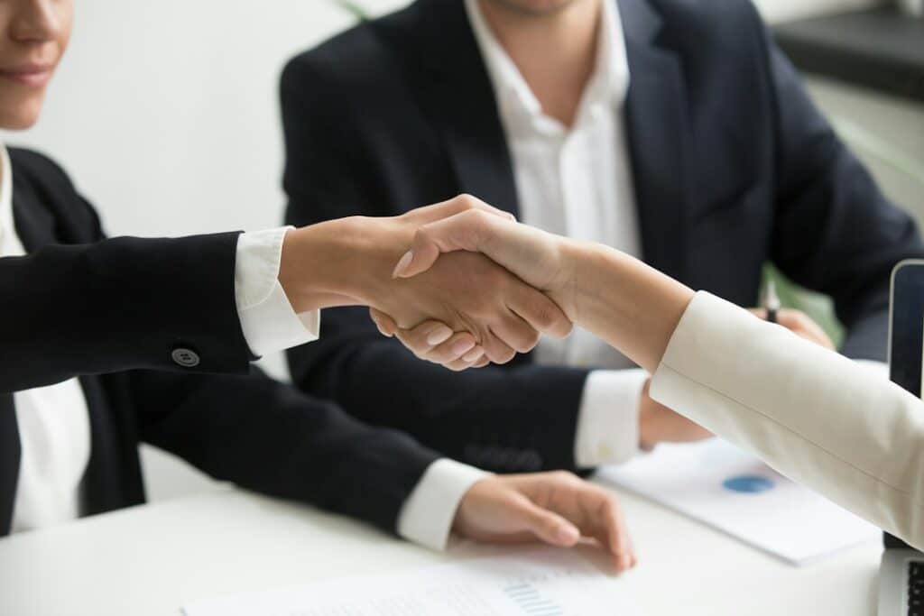 Employer and new hire shaking hands after choosing a staffing model
