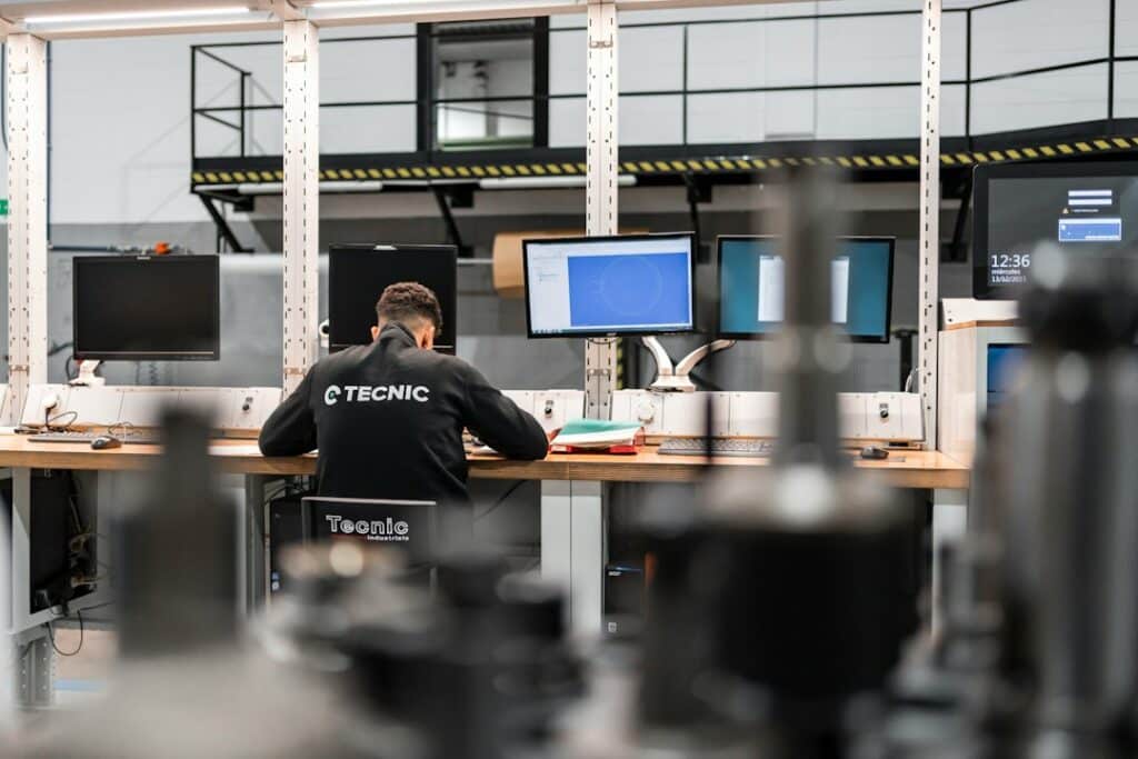Industrial engineer analyzing production data at a workstation in a plant
