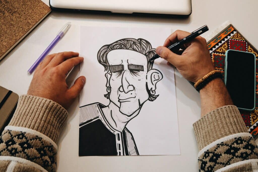 Artist hand-drawing a cartoon character in black ink on paper, a traditional animation technique