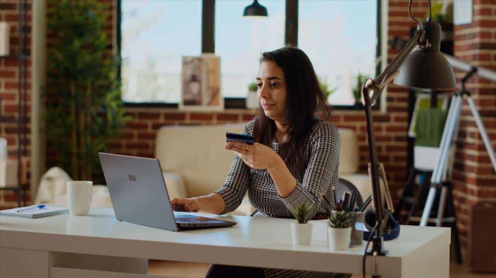 Business owner adding a payment card while ordering online at her desk
