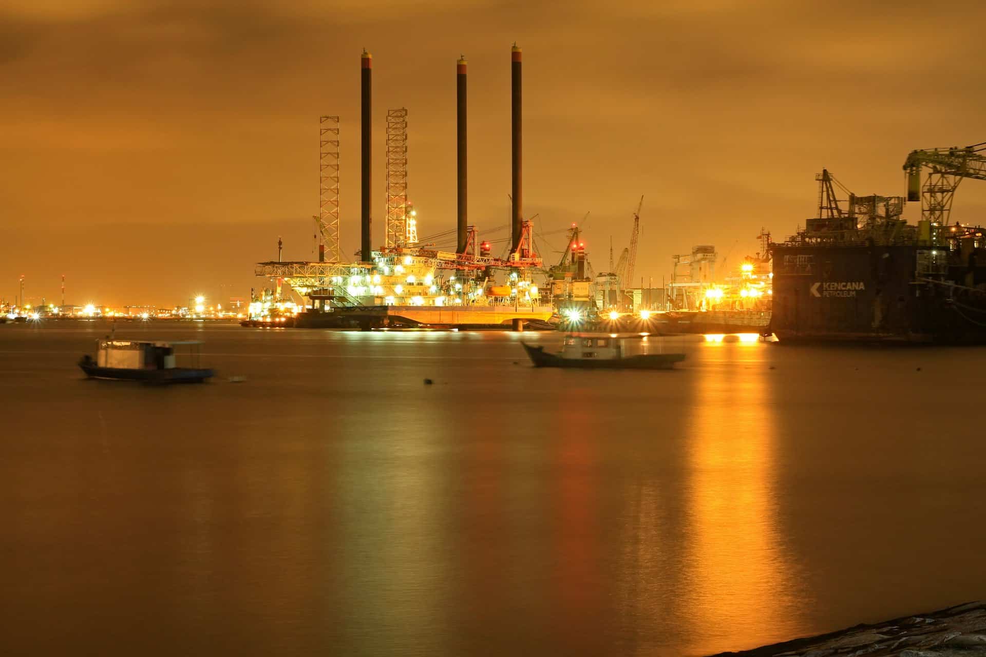 Oil refinery lit up at night across the water