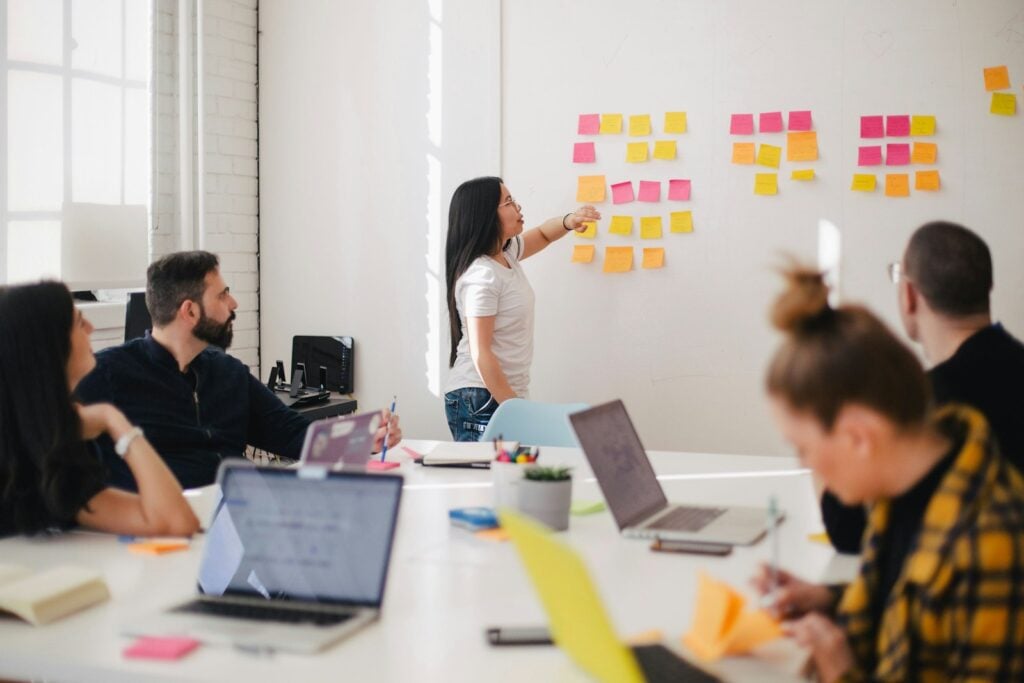 Team reviewing sticky-note feedback on a wall during a workplace culture discussion
